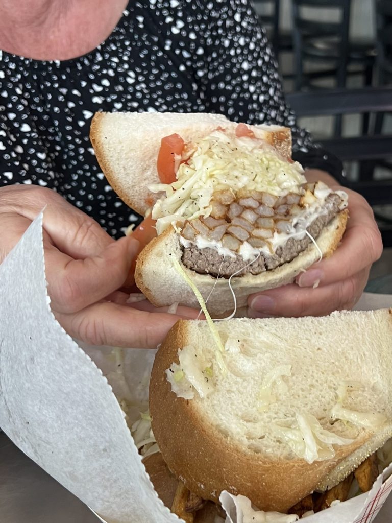 Hamburger topped with French fries, Cole slaw, and tomato on Cellone's fresh italian bread at Primanti Brothers Fort Lauderdale Florida