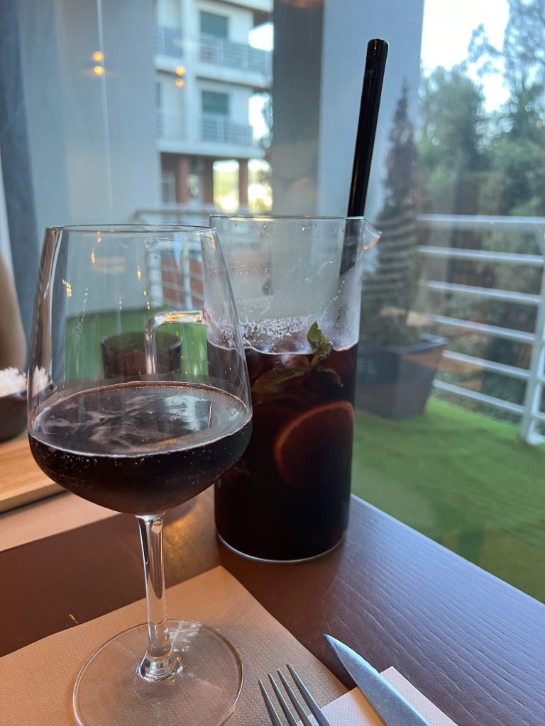 Glass of Sangria in foreground with pitcher of sangria in background at Bandalho Meat & Wine Carnaxide — Lisbon Restaurant Review — Portugal Food Blog