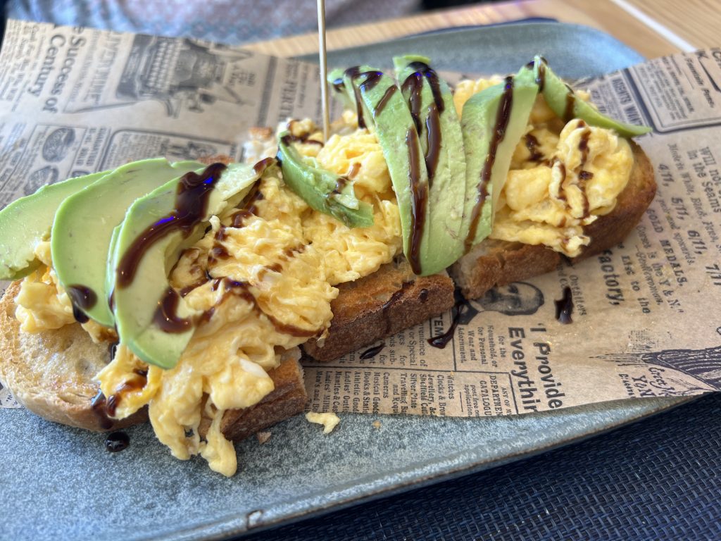 Sourdough toast with scrambled eggs, avocado slices, and balsamic drizzle — Almalusa Brunch in Armação de Pêra, Portugal