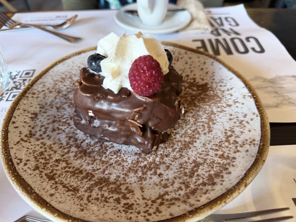 Chocolate brownie dessert with fresh raspberry and blueberry garnish — Come na gaveta tavira photo review