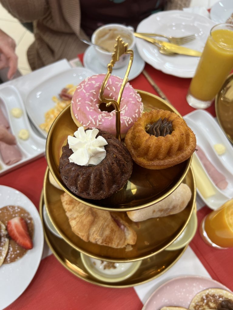 Sweets tower with a pink iced donut, a chocolate mini bundt cake with whipped cream inside and a vanilla mini bundt with Nutella inside at MB Cakes Brunch & Coffee Photos & Review