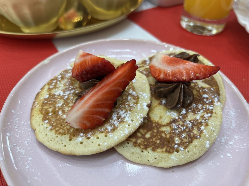 Two small pancakes topped with Nutella and fresh strawberries and a dusting of powdered sugar at MB Cakes Brunch & Coffee Photos & Review