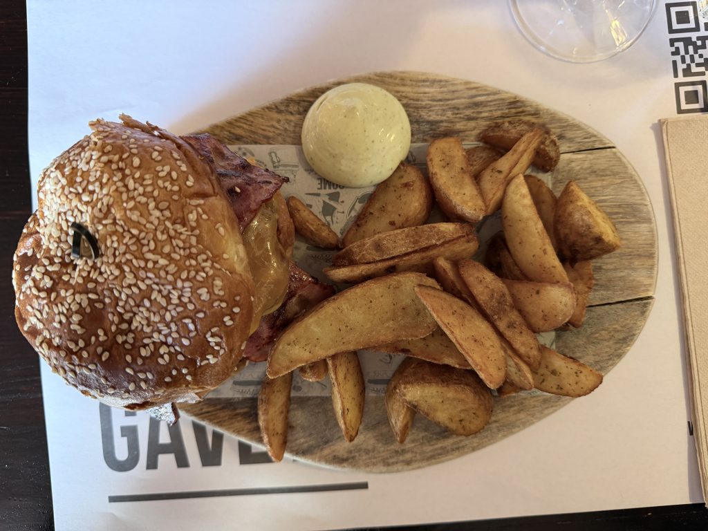 Overhead view of double bacon cheeseburger on sesame seed bun with potato wedges and garlic aioli — Come na gaveta tavira review photo