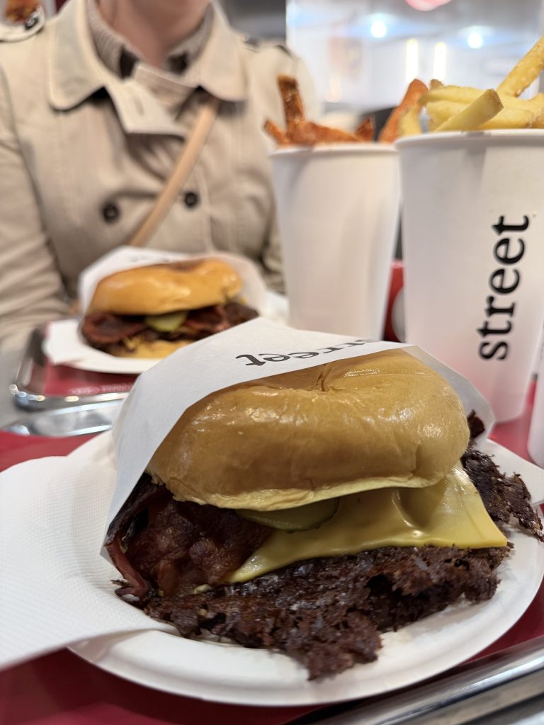 Street Smash Burger Lisbon Review Alvalade Photos | View of a Street Smash Burger on a plate with 2 cups of fries and a second smash burger in the background | Best Smash Burger in Lisbon?