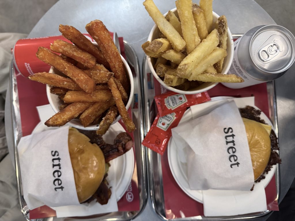 Street Smash Burger Lisbon Review Alvalade Photos | Top down view of 2 smash burgers, a cup of fries, a cup of sweet potato fries, and a can of beer | Best Smash Burger in Lisbon?