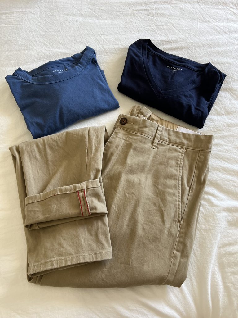 A flat lay of 2 t shirts and 1 pair of khaki chinos from Mott & Bow
One tee is a Driggs crewneck in baltic blue. The second tee is a Driggs v neck in navy blue.