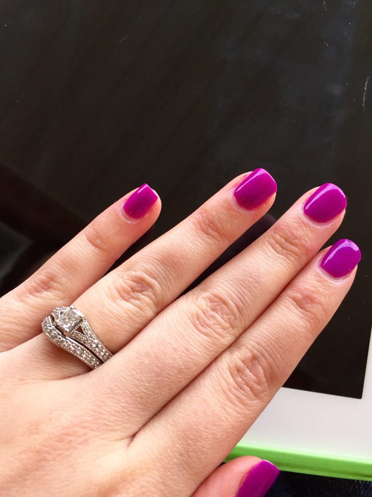 Woman's hand with fuchsia pink purple gel manicure