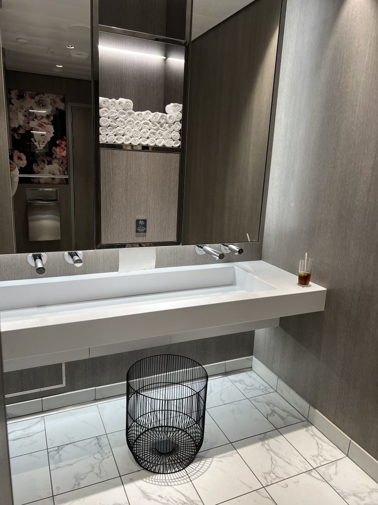 Women's Restroom with rolled towels for drying hands above a trough sink | Celebrity Ascent Review