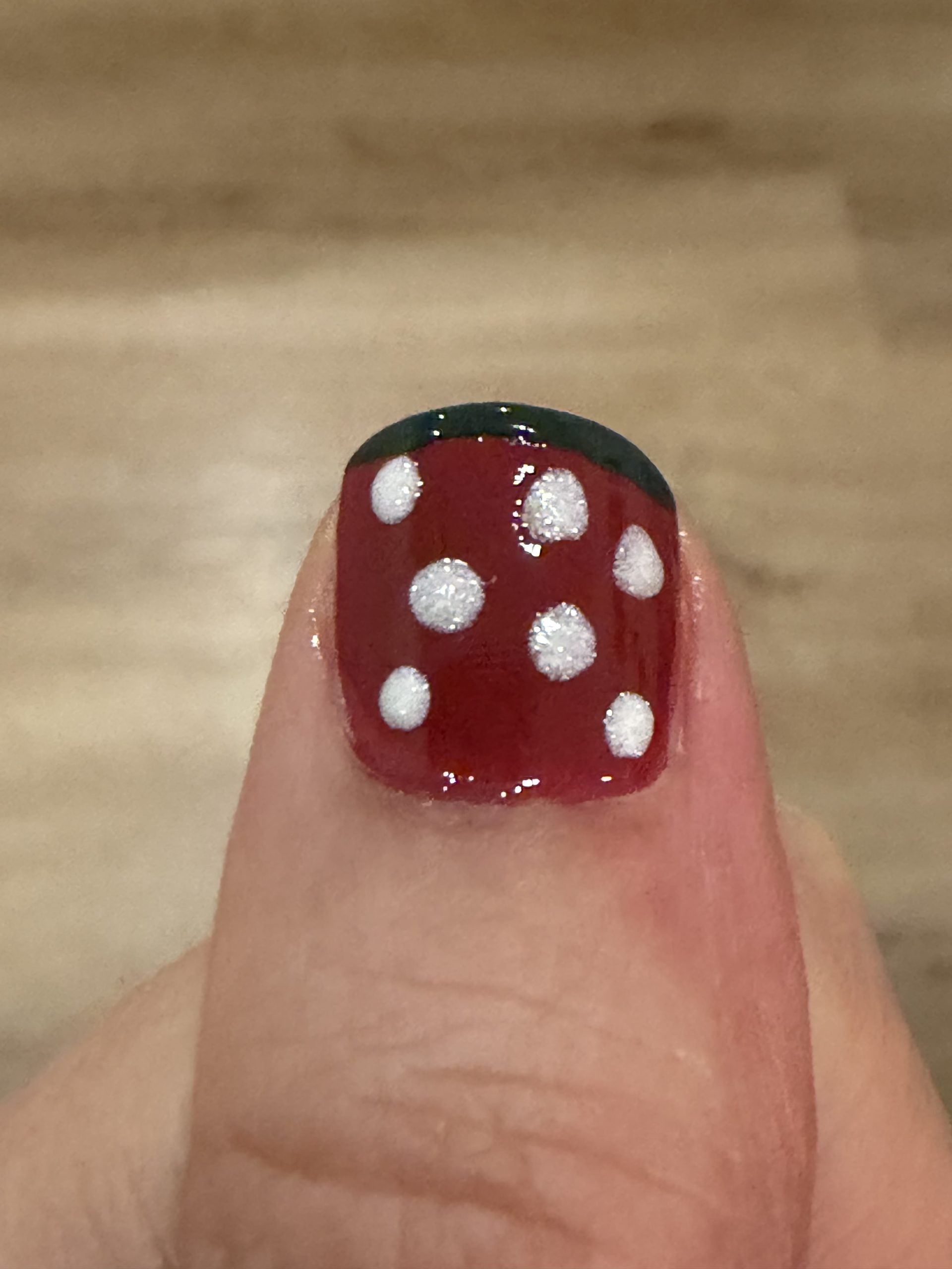 Manucurist World of Wonders Collection Nail Art Ideas Thin Forest Green French Tip on Red Nail with White Sparkly Polka Dots