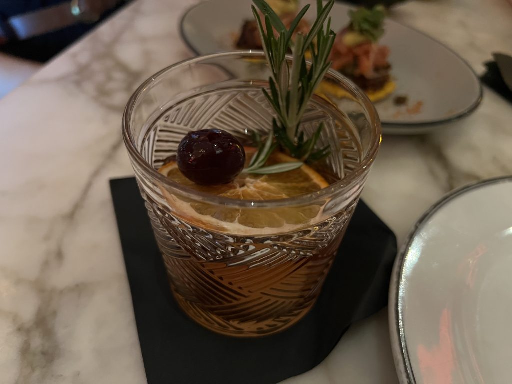Marabu Miami Review — Cuban Old Fashioned Cocktail garnished with orange slice, rosemary sprig, and luxardo cherry | Miami Happy Hour Cuban Restaurant