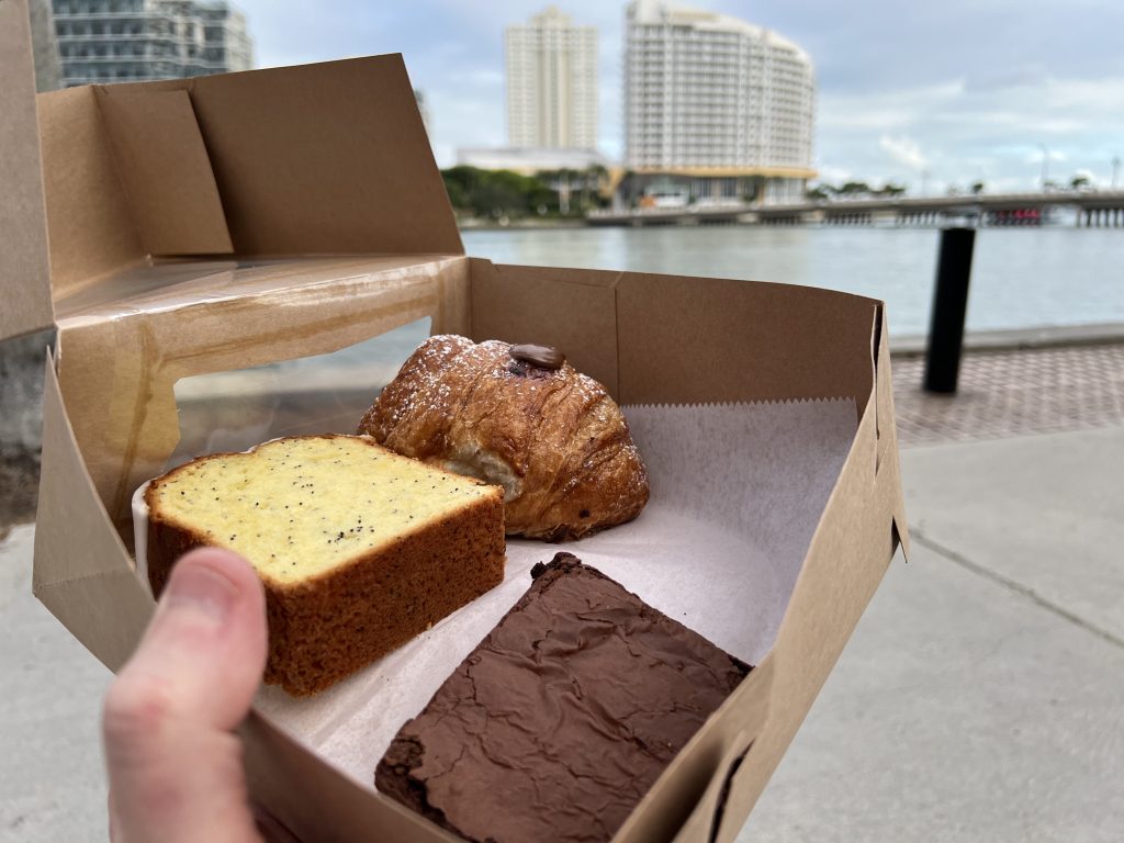 Raccoon Coffee & Kitchen Brickell Reviews — Box with pastries Miami River in Background | Too Good To Go Miami Discount